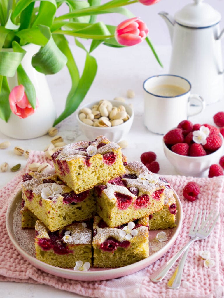 Protein Pistazienkuchen mit Himbeeren in Stückchen geschnitten auf einem Teller