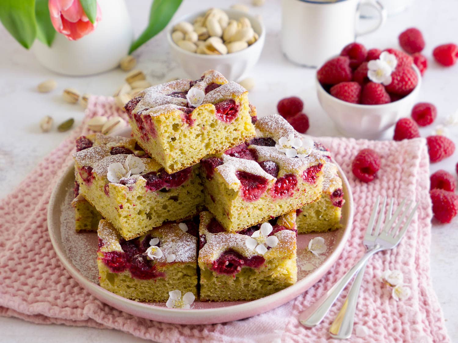 Protein Pistazienkuchen mit Himbeeren in Stückchen geschnitten auf einem Teller