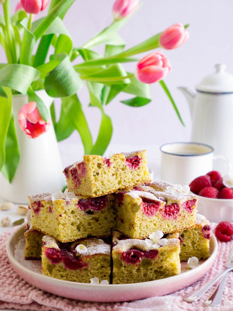Protein Pistazienkuchen mit Himbeeren in Stückchen geschnitten auf einem Teller