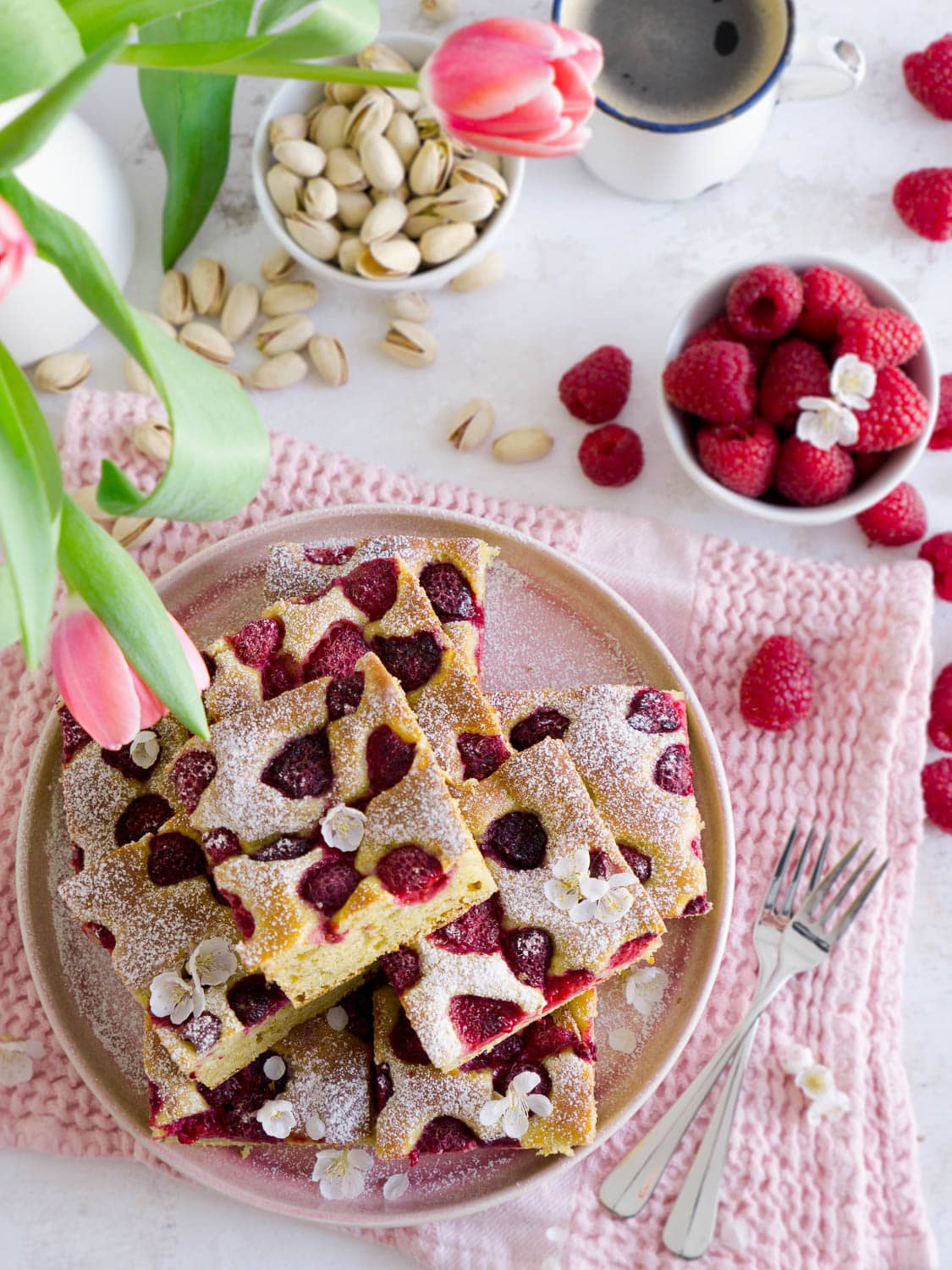 Protein Pistazienkuchen mit Himbeeren in Stückchen geschnitten auf einem Teller
